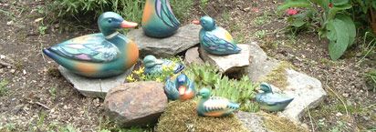 Keramikfiguren auf Steinen im Garten